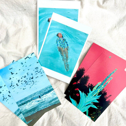 Four colorful postcards on a white fabric background